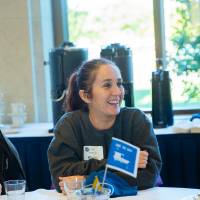 Three alumni sitting at a table enjoying conversation at the Laker Legacy Brunch